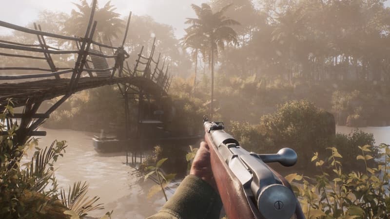 A soldier aiming across a river beside a bamboo bridge